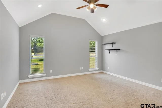 an empty room with windows and fan
