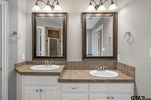 a bathroom with double vanity sinks and a mirror