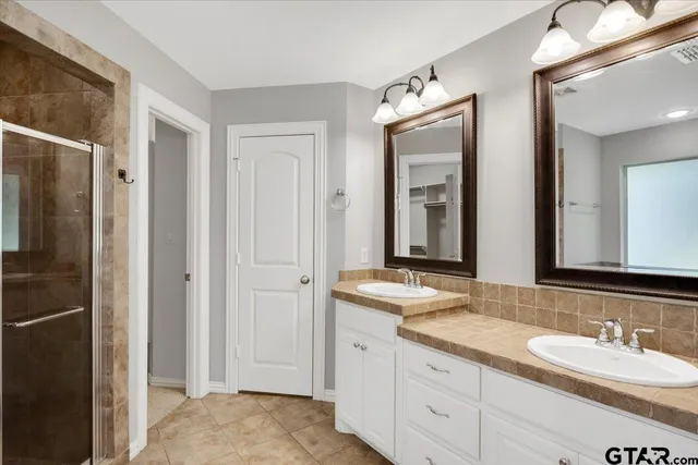 a bathroom with double sink and a mirror
