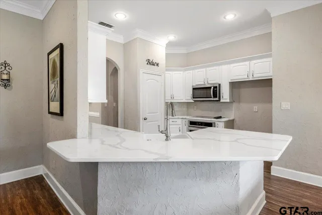 a kitchen with stainless steel appliances a sink and a refrigerator
