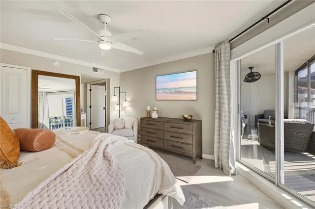 a spacious bedroom with a bed a couch and large window