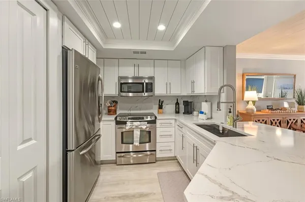 a kitchen with microwave a stove and chairs