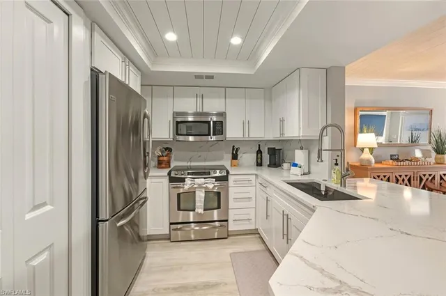 a kitchen with microwave a stove and chairs