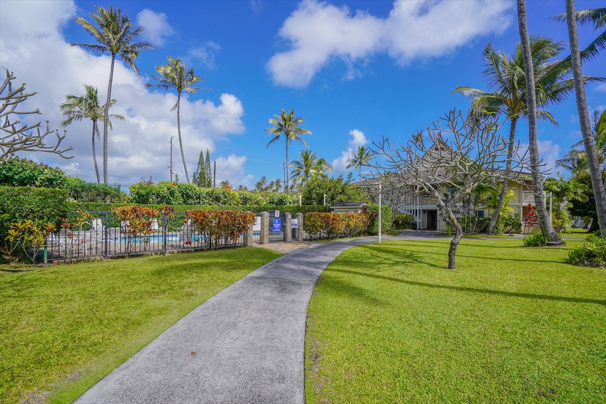 5-25 Aleka Loop, Unit J6 Kapaa, HI 96746 - Photo 17 of 17 a view of a fountain in front of a house with a big yard and palm trees