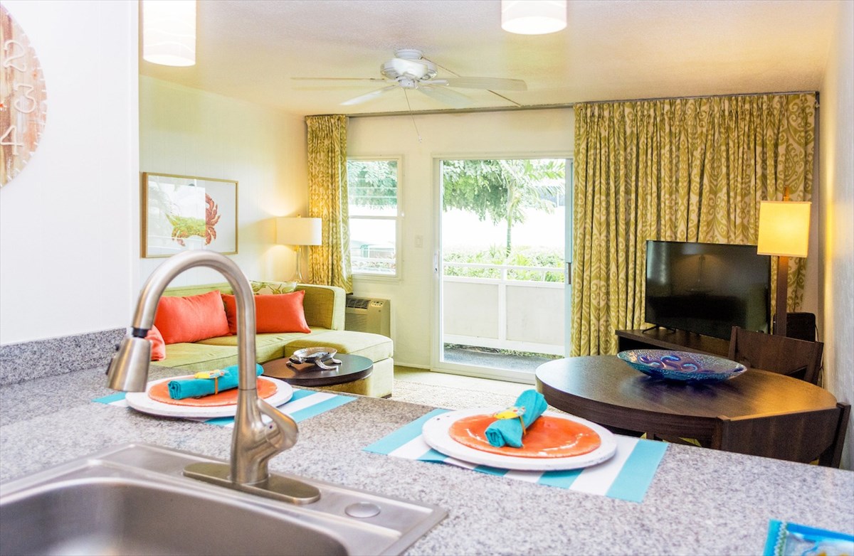 5-25 Aleka Loop, Unit J6 Kapaa, HI 96746 - Photo 8 of 17 a living room with furniture a flat screen tv and a floor to ceiling window