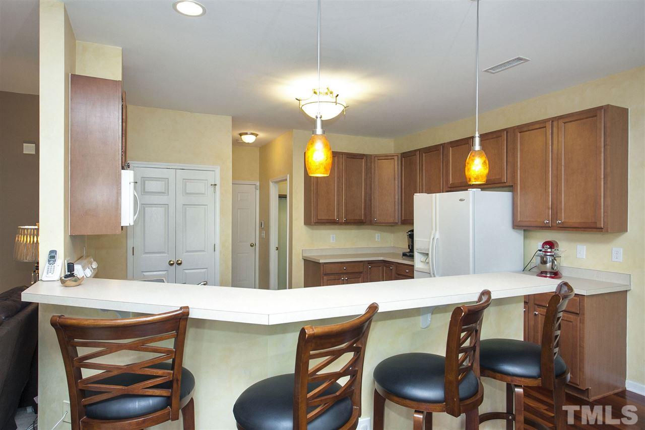 308 Inkster Cove Raleigh, NC 27603 - Photo 7 of 25 a kitchen with a dining table chairs sink and wooden floor