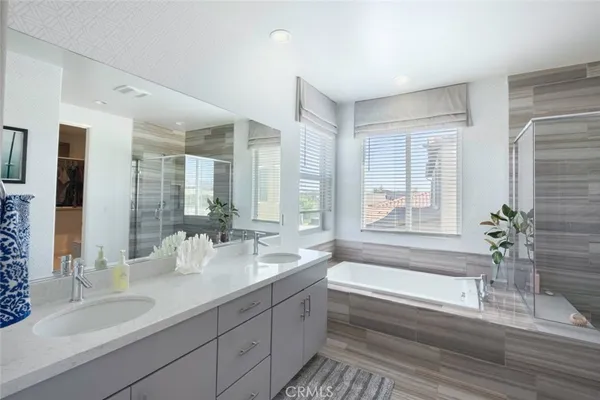 a bathroom with a granite countertop tub a sink and a large mirror