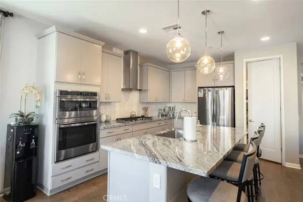 a kitchen with stainless steel appliances granite countertop a stove refrigerator and cabinets
