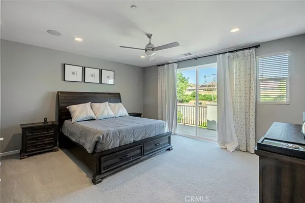 a spacious bedroom with a bed and a television