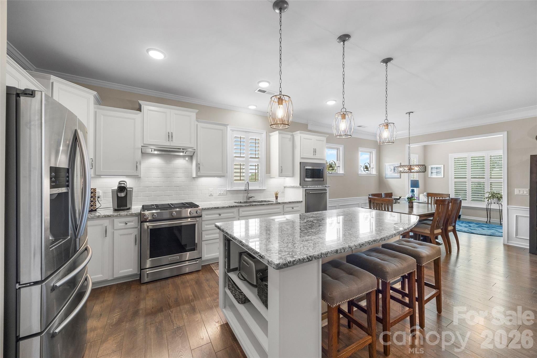 836 Bliss Drive Fort Mill, SC 29715 - Photo 9 of 47 a large kitchen with granite countertop a stove a sink a kitchen island a dining table and chairs