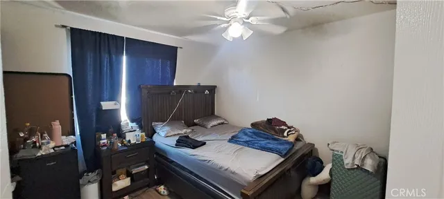 a bedroom with a bed and a potted plant