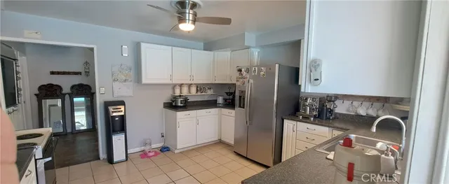 a kitchen with a sink white cabinets and stainless steel appliances