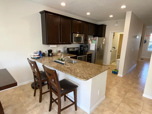 a kitchen with stainless steel appliances granite countertop wooden cabinets a refrigerator and a sink