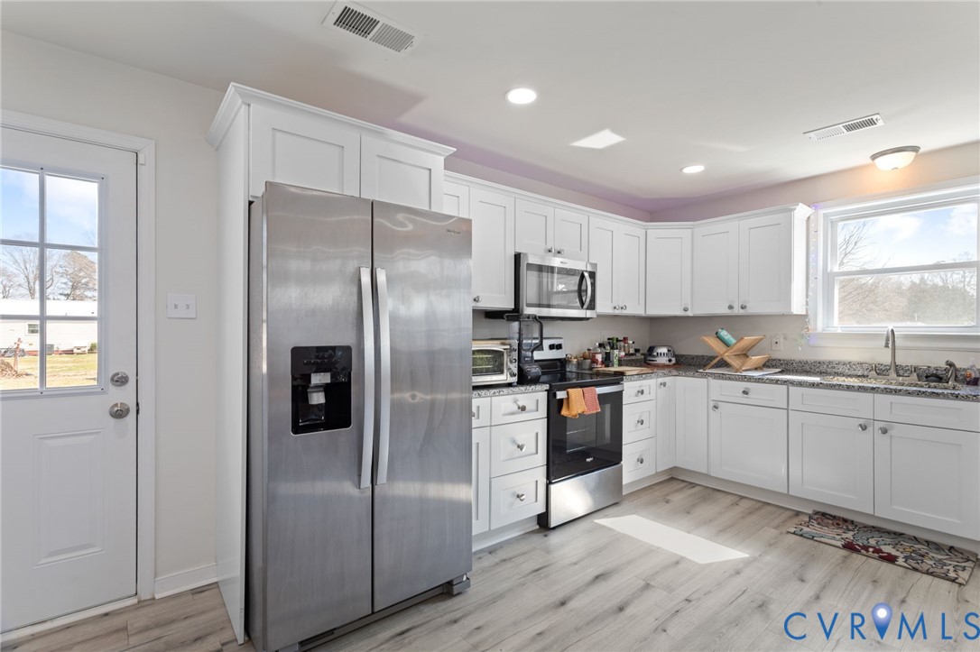 7547 Media Park Road Henrico, VA 23231 - Photo 1 of 24 a kitchen with stainless steel appliances granite countertop a refrigerator a sink dishwasher a stove and white countertops with wooden floor