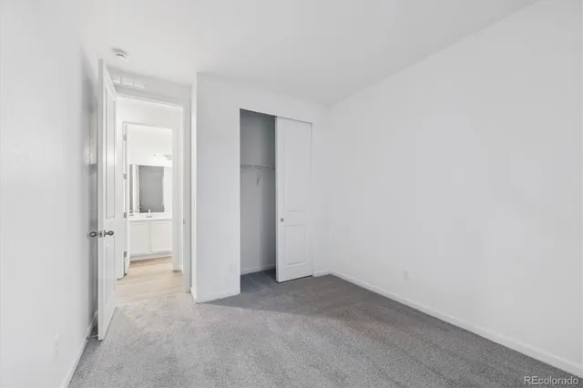 an empty room with closet and a bathroom