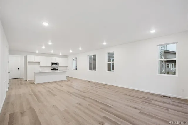 a view of kitchen with kitchen island microwave and wooden floor
