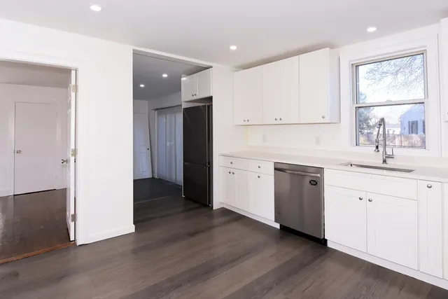 a kitchen with a sink cabinets stainless steel appliances and a window