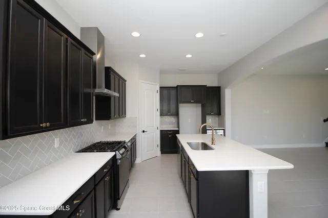 a kitchen that has a sink and a stove in it