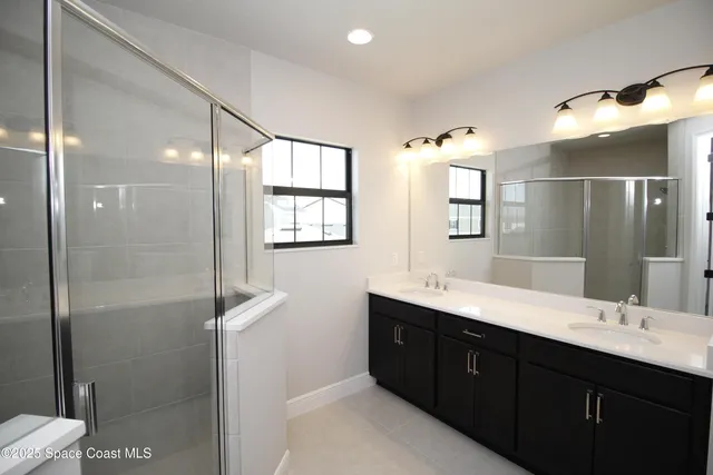 a bathroom with a double vanity sink toilet and shower
