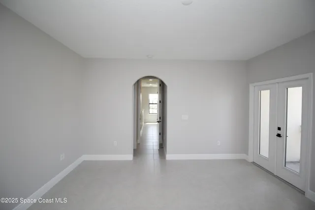 a view of an empty room with closet and windows