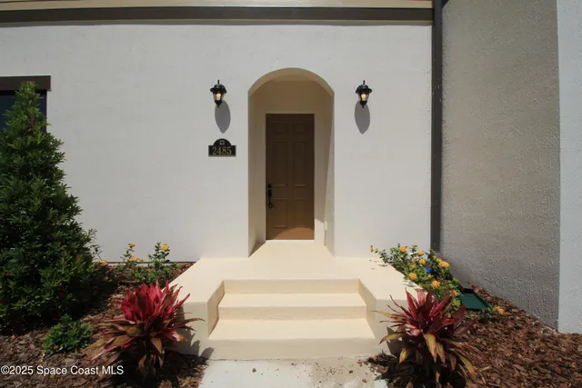 a front view of a house with a flower garden
