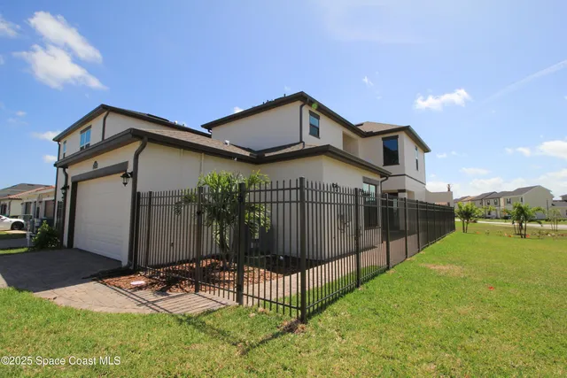 a view of a house with brick walls and a small yard