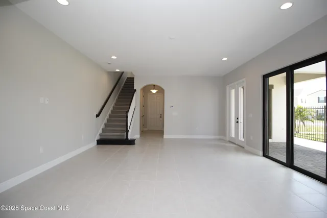 a view of an empty room with a sliding door and wooden floor