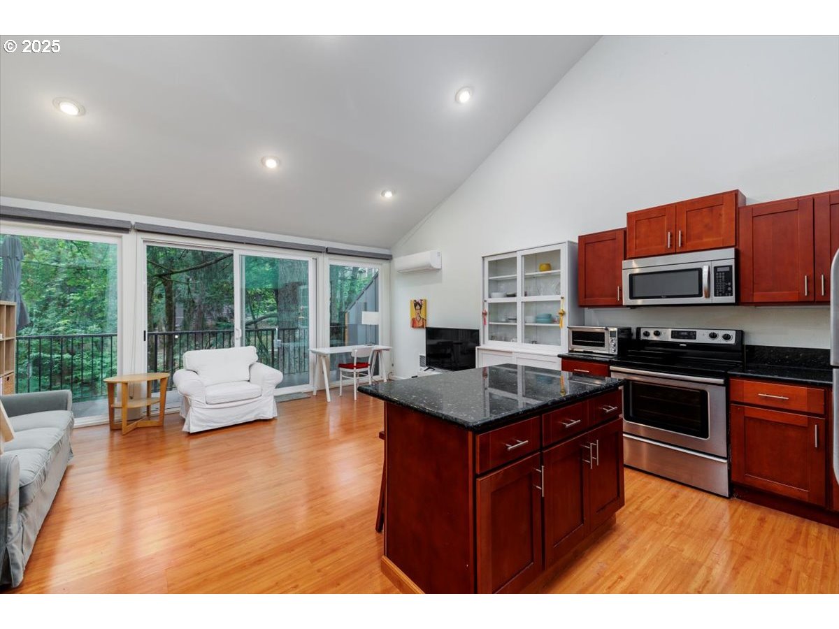100 Kerr Parkway, Unit 34 Lake Oswego, OR 97035 - Photo 12 of 35 a kitchen with stainless steel appliances granite countertop a stove top oven a sink dishwasher with couches with wooden floor