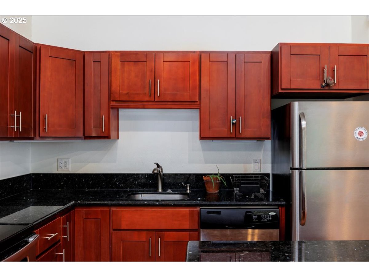 100 Kerr Parkway, Unit 34 Lake Oswego, OR 97035 - Photo 14 of 35 a kitchen with stainless steel appliances granite countertop a refrigerator a sink dishwasher with a microwave oven and cabinets