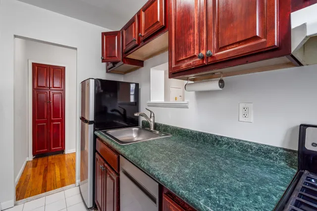 a kitchen with granite countertop a sink a stove and cabinets