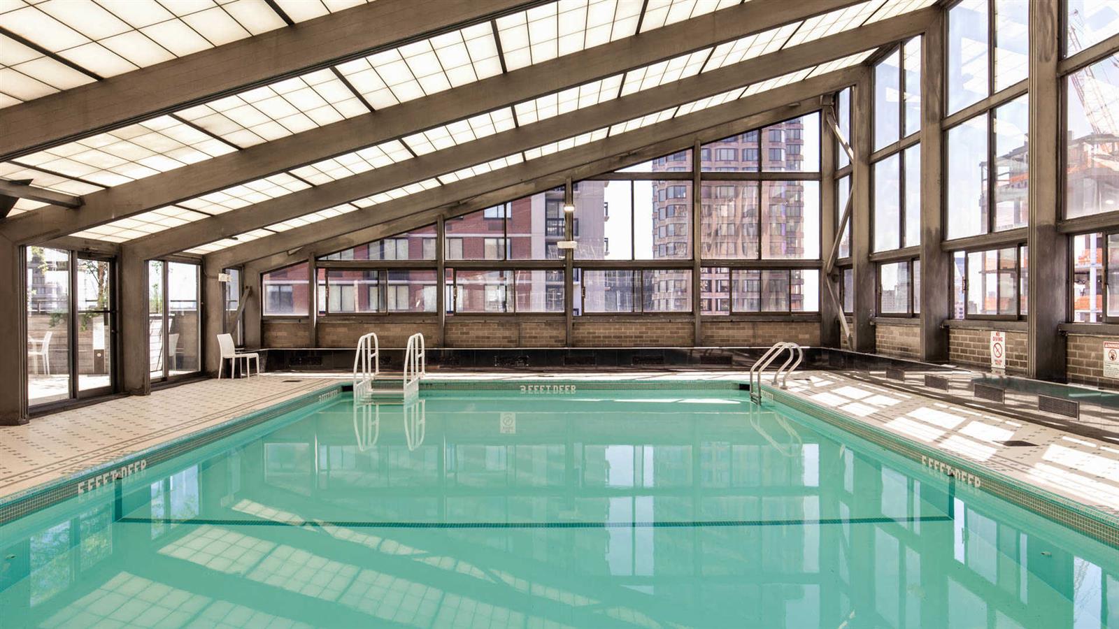 245 East 40th Street, Unit 24J Manhattan, NY 10016 - Photo 8 of 10 a view of a swimming pool with a lounge chairs