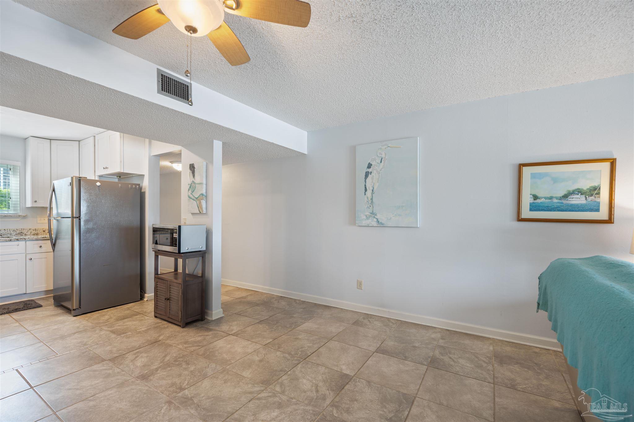 14100 River Road, Unit 228B Pensacola, FL 32507 - Photo 8 of 41 a view of a kitchen with a refrigerator cabinets and a ceiling fan