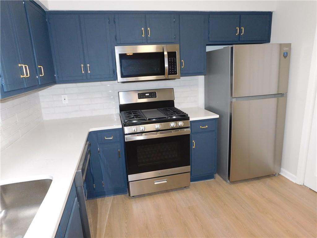 3589 North Hopkins Court Powder Springs, GA 30127 - Photo 7 of 17 a kitchen with a refrigerator stove and microwave