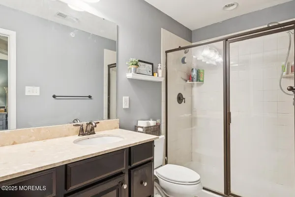 a bathroom with a granite countertop sink toilet a large mirror a shower and a mirror