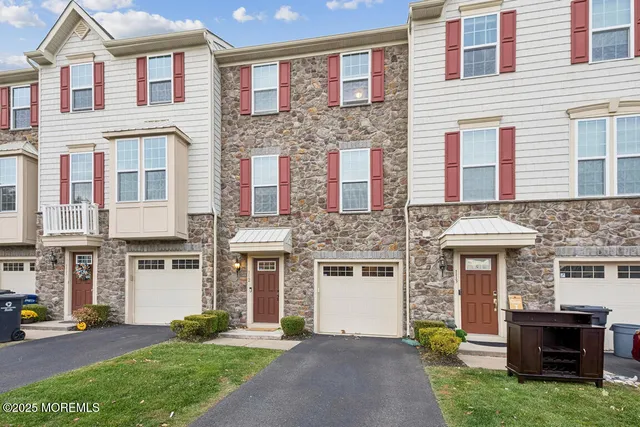 a front view of a house with a garden and plants