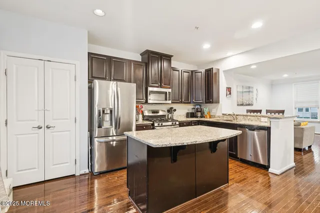 a kitchen with stainless steel appliances granite countertop a refrigerator a sink and a stove
