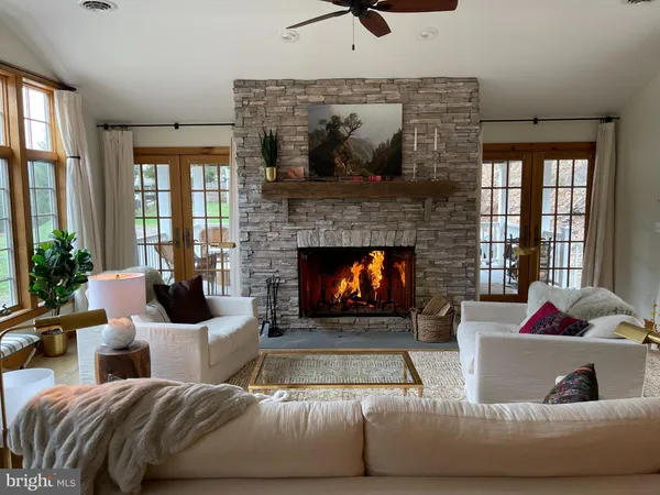 a living room with furniture large windows and a fireplace