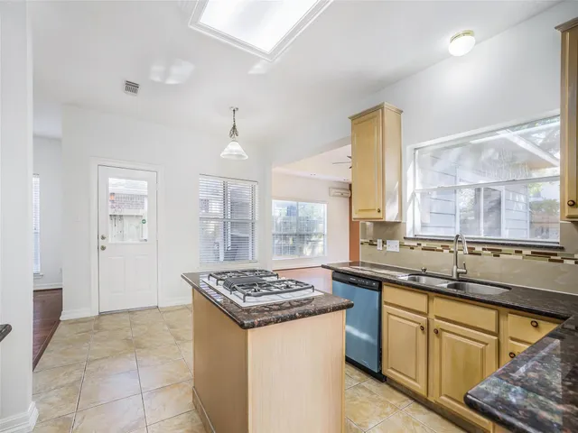 a kitchen with stainless steel appliances granite countertop a sink and a stove