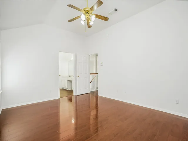 a view of empty room with wooden floor