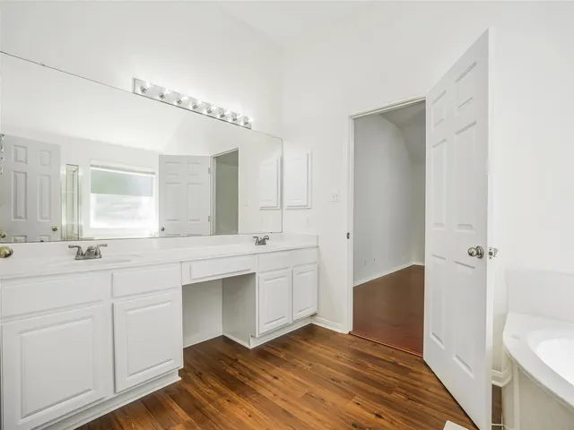 a spacious bathroom with a double vanity sink a mirror and a toilet