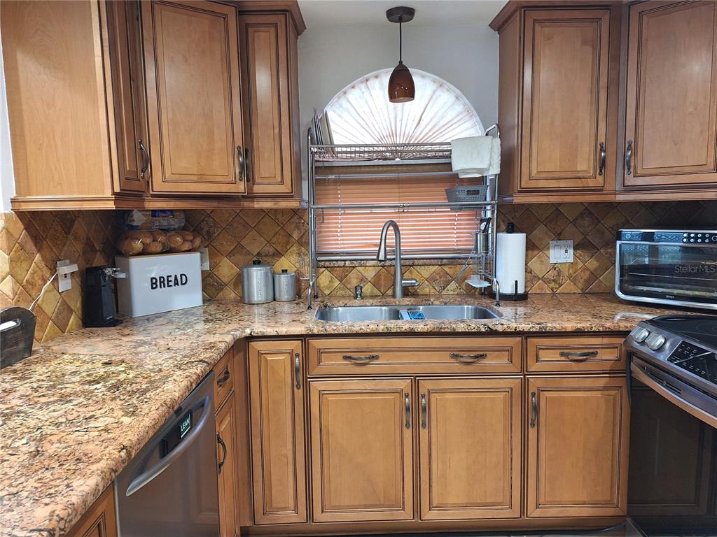 9415 Indale Drive New Port Richey, FL 34654 - Photo 17 of 93 a kitchen with granite countertop a sink stainless steel appliances and cabinets