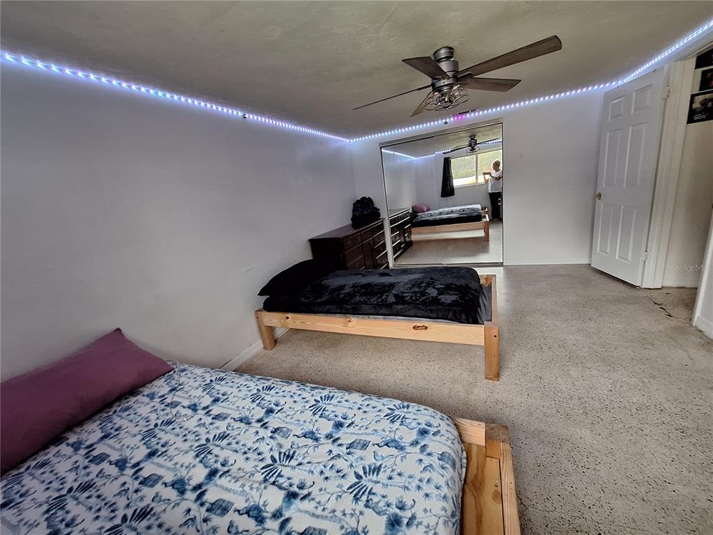 9415 Indale Drive New Port Richey, FL 34654 - Photo 41 of 93 a bedroom with a bed and a chandelier