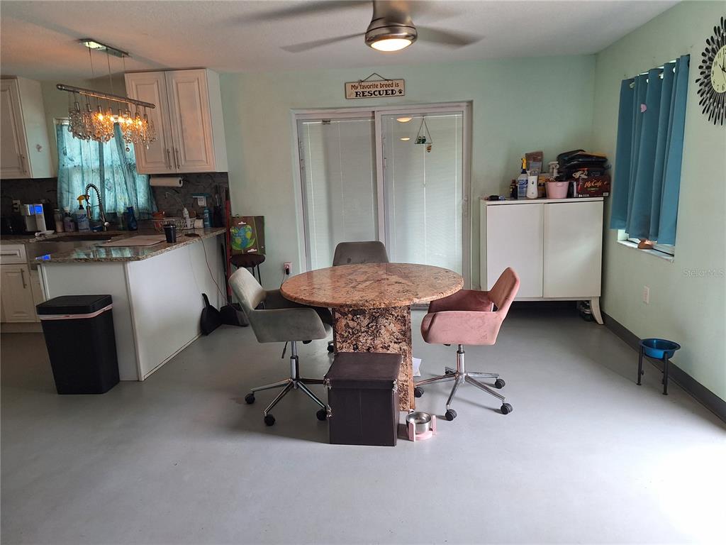 9415 Indale Drive New Port Richey, FL 34654 - Photo 75 of 93 a kitchen with a table chairs and a refrigerator