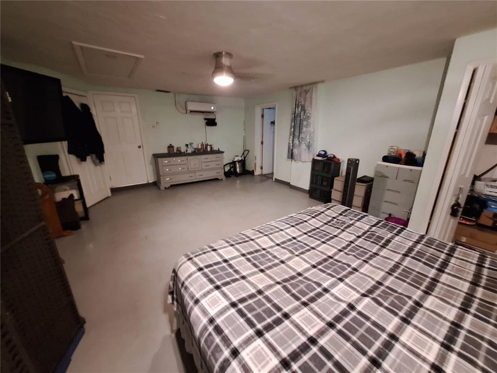 9415 Indale Drive New Port Richey, FL 34654 - Photo 80 of 93 a bedroom with a bed and a flat tv screen on dresser