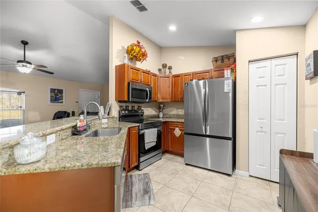 a kitchen with granite countertop a refrigerator and a sink