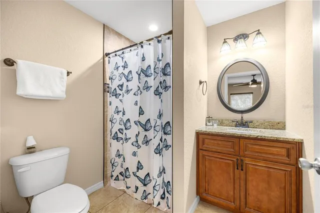 a bathroom with a toilet sink vanity tub and mirror