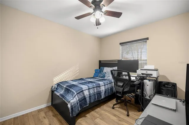 a bedroom with a bed and a computer on a desk