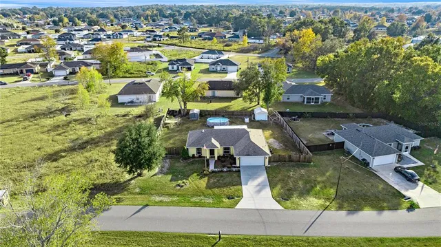 an aerial view of residential houses with outdoor space and swimming pool