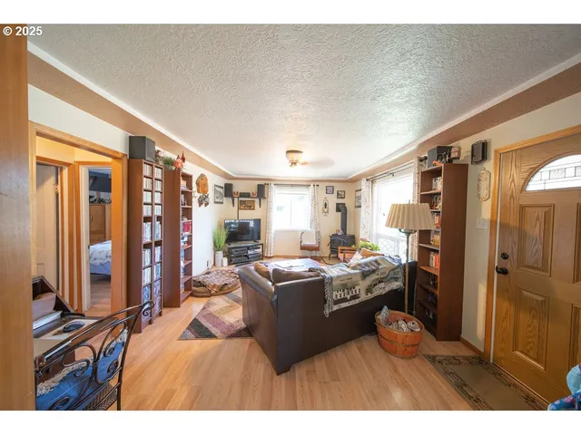 a living room with furniture a flat screen tv and a refrigerator
