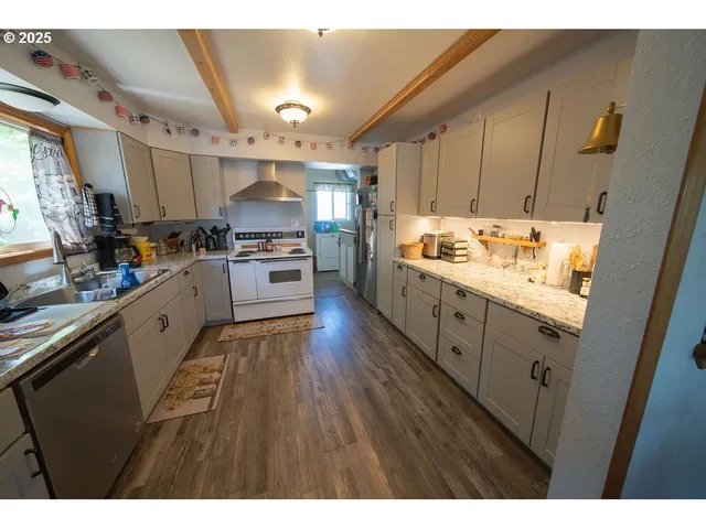 a kitchen with stainless steel appliances granite countertop a sink stove and refrigerator